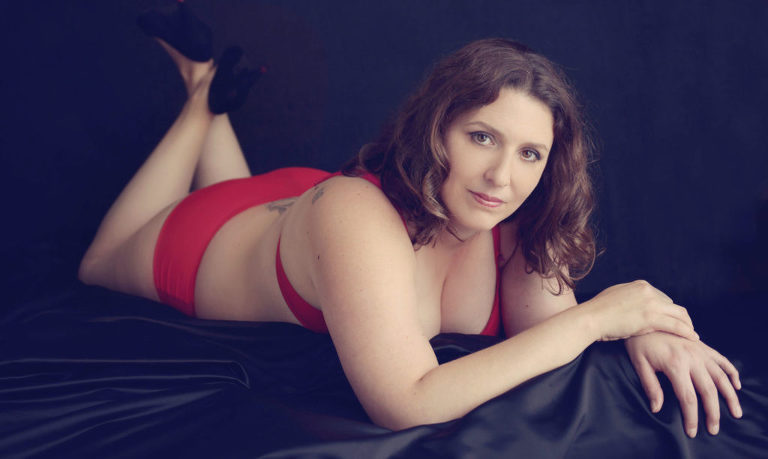 boudoir photo session with red lingerie laying on front