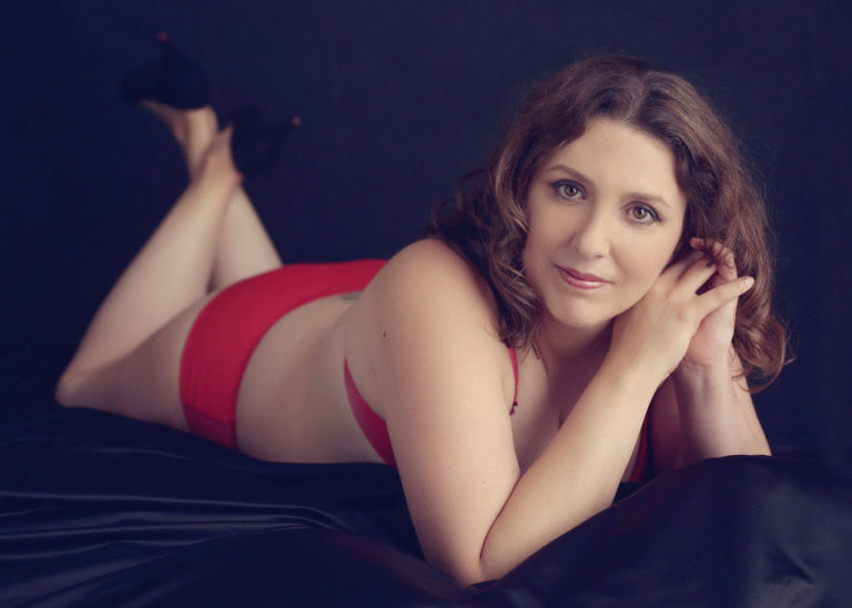 boudoir photo session with red bra and knickers and hands by face